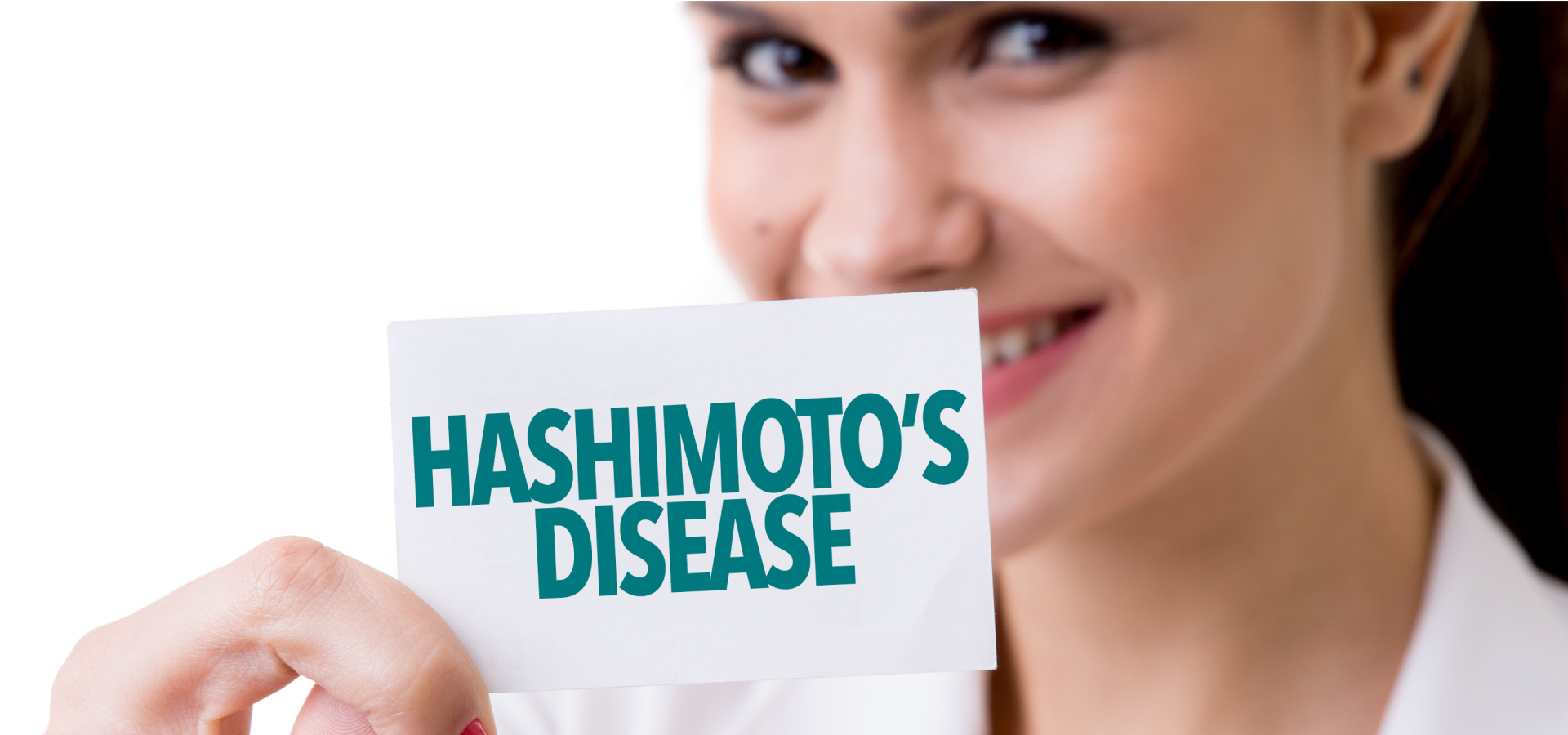 A woman holding a little sign with the words "Hashimoto's disease"