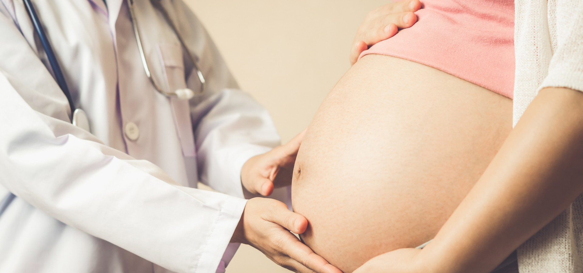Doctor placing her hands on a pregnant woman's belly